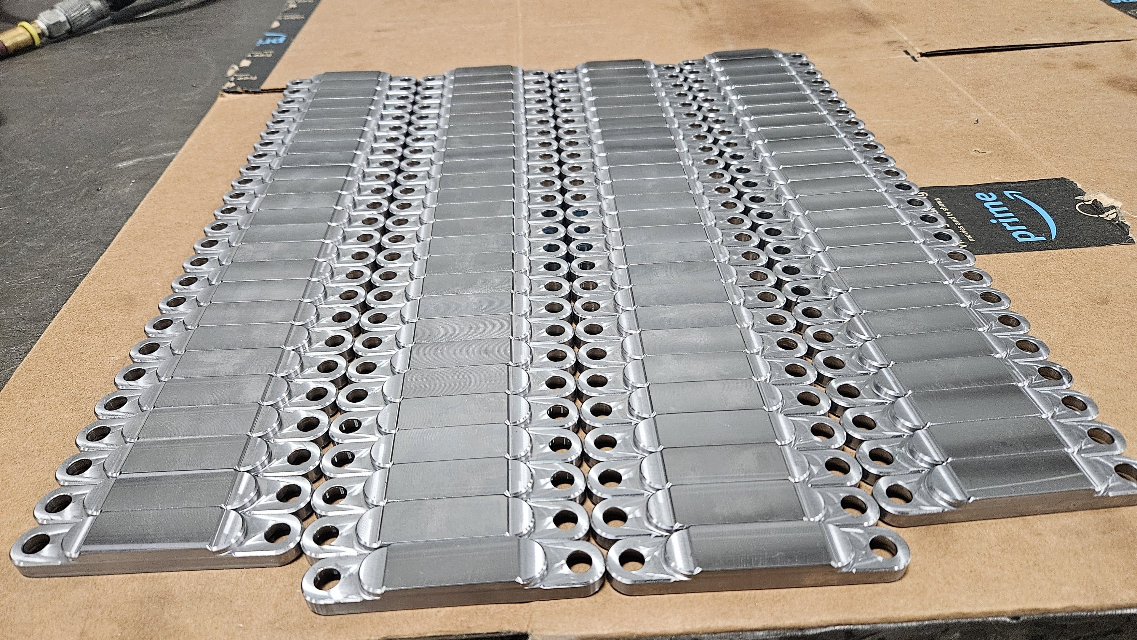 Stacked machined aluminum link plates with precision-drilled mounting holes