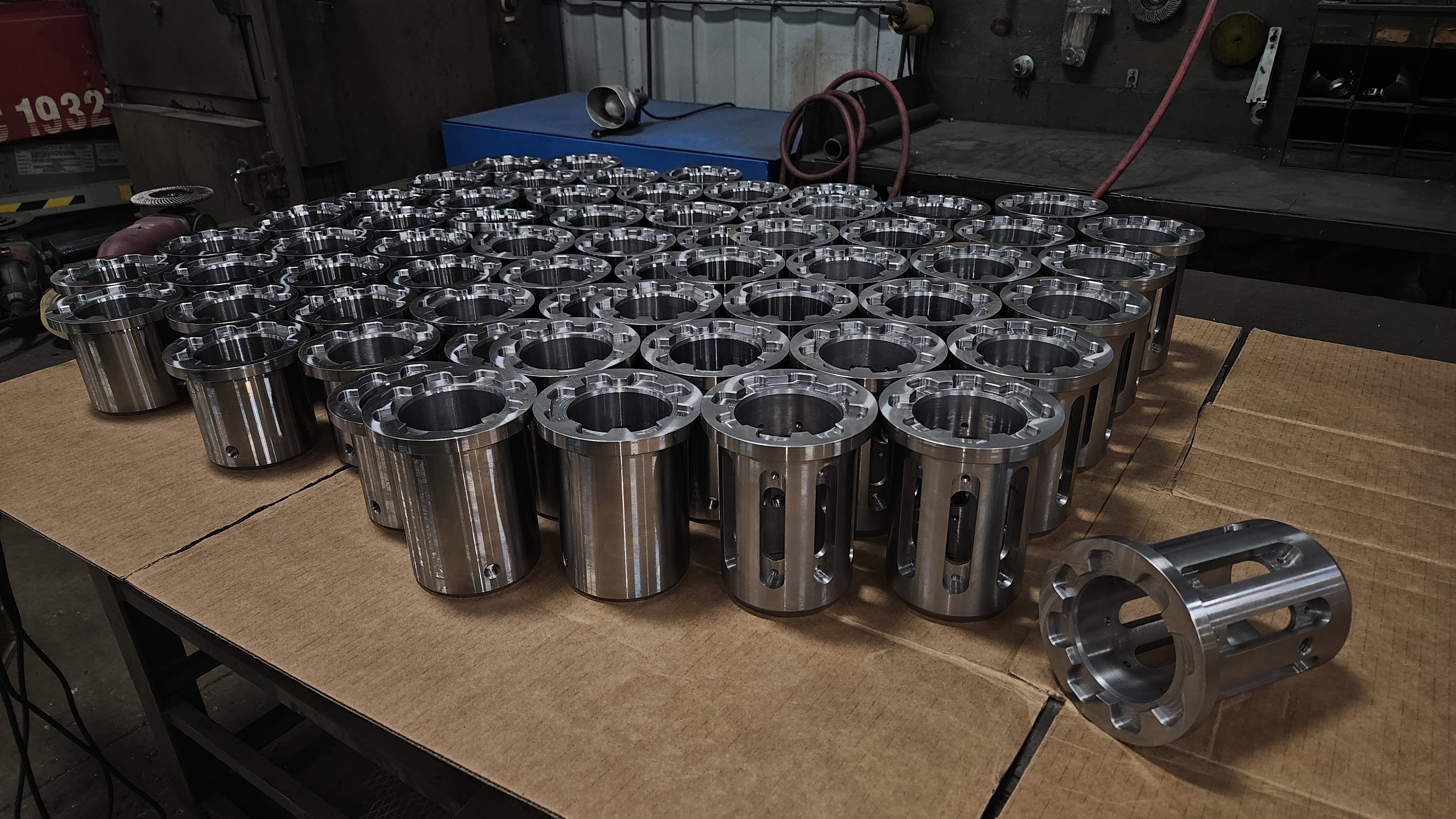 Array of fluted stainless steel cylindrical bushings machined on a lathe