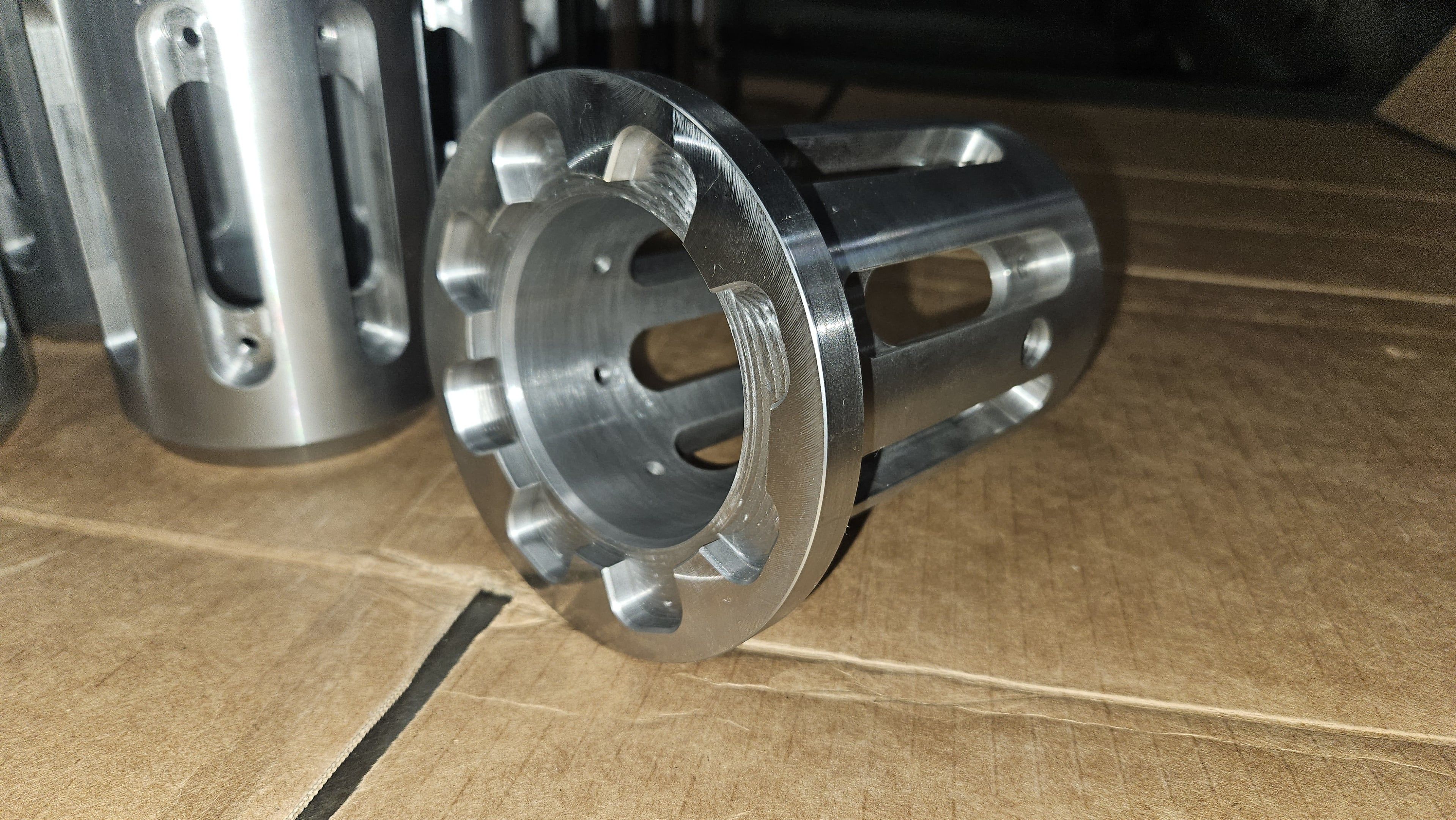 Close-up of a machined aluminum coupling with fluted slots and bolt holes