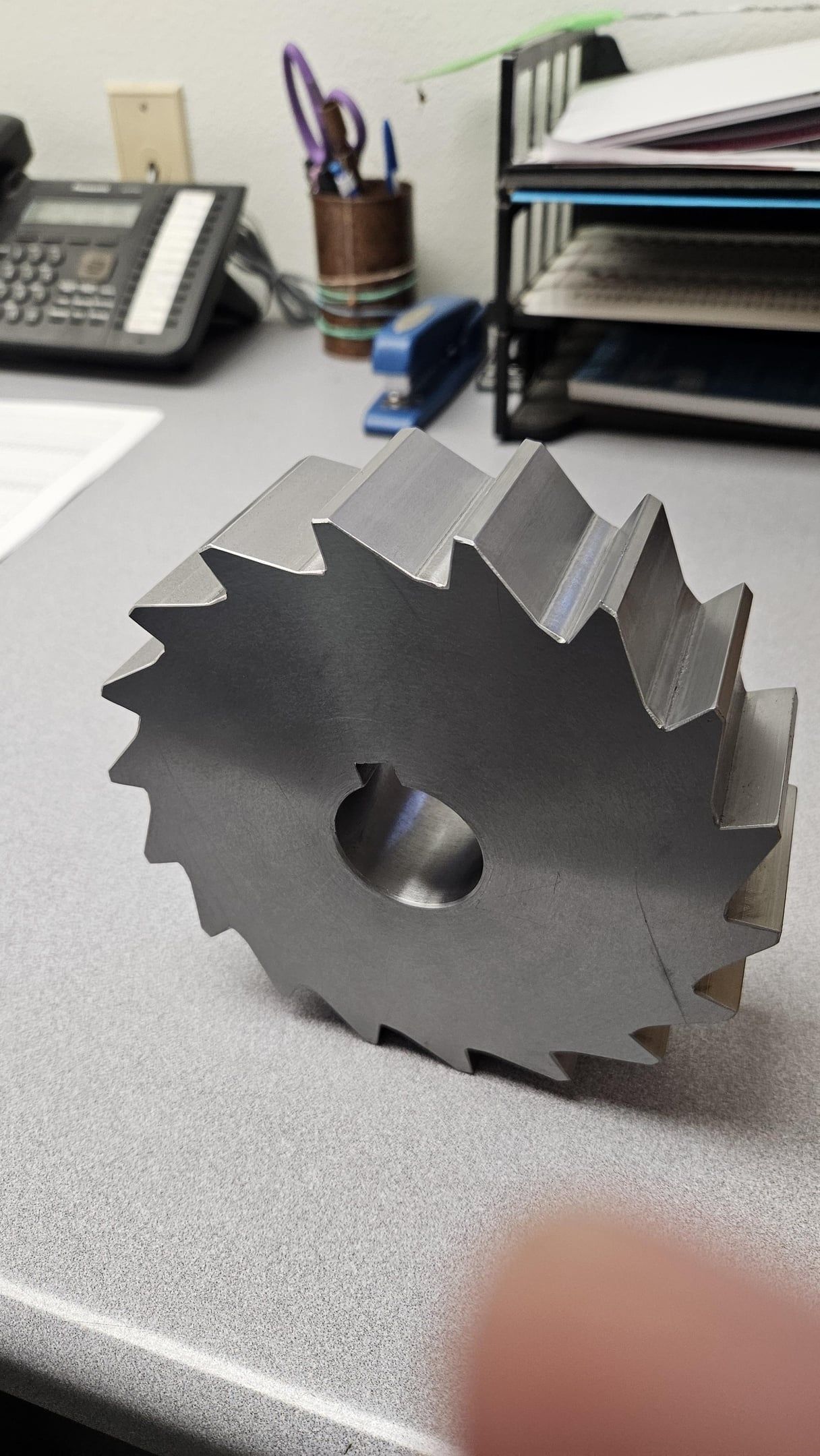 Large steel gang milling cutter with saw-tooth carbide inserts on a desk
