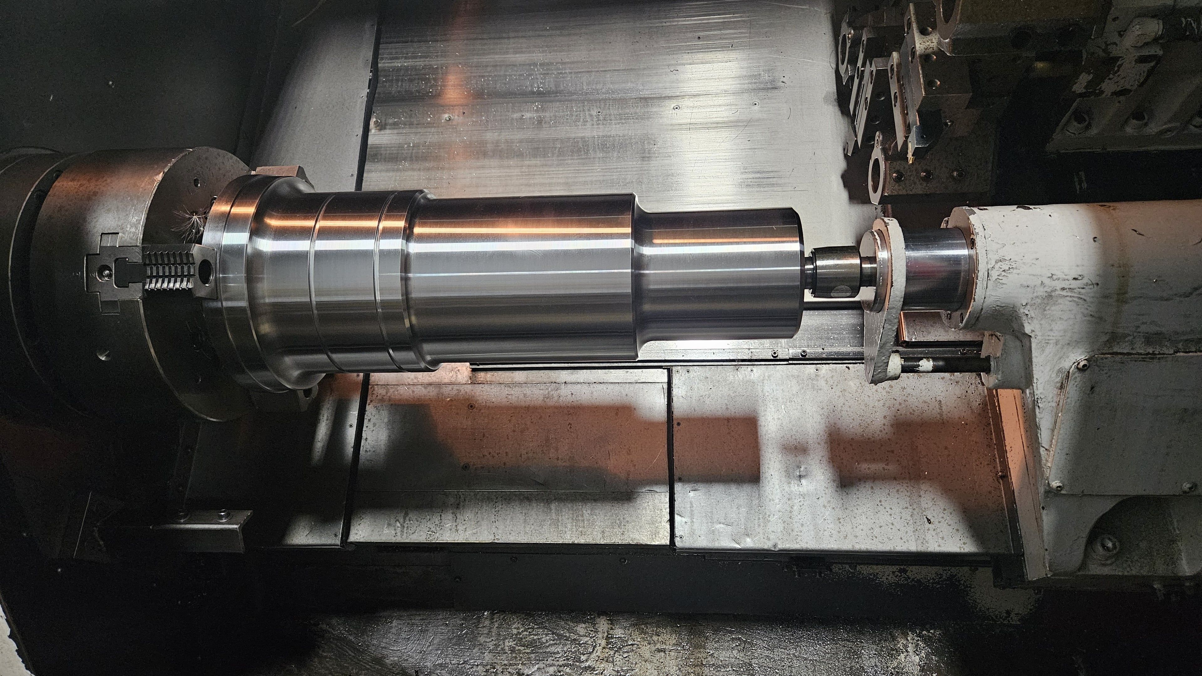Long stepped steel shaft turned to size on a CNC lathe